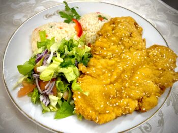 Snitel de pui pane cu pilaf de orez si salata verde cu rosii, castraveti si cepa verde